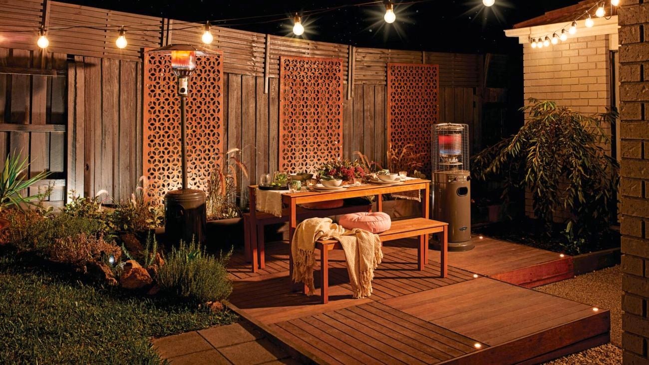 Danced outdoor entertaining area with wooden deck, wooden bench and seats, and outdoor gas heater.