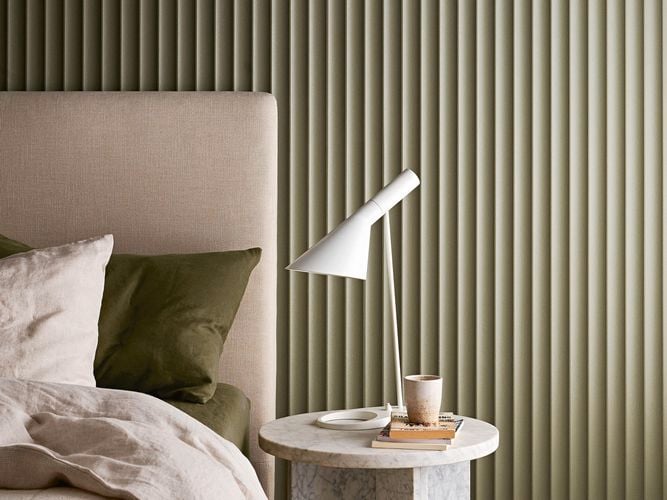 Bedroom area with a panelled wall in the background