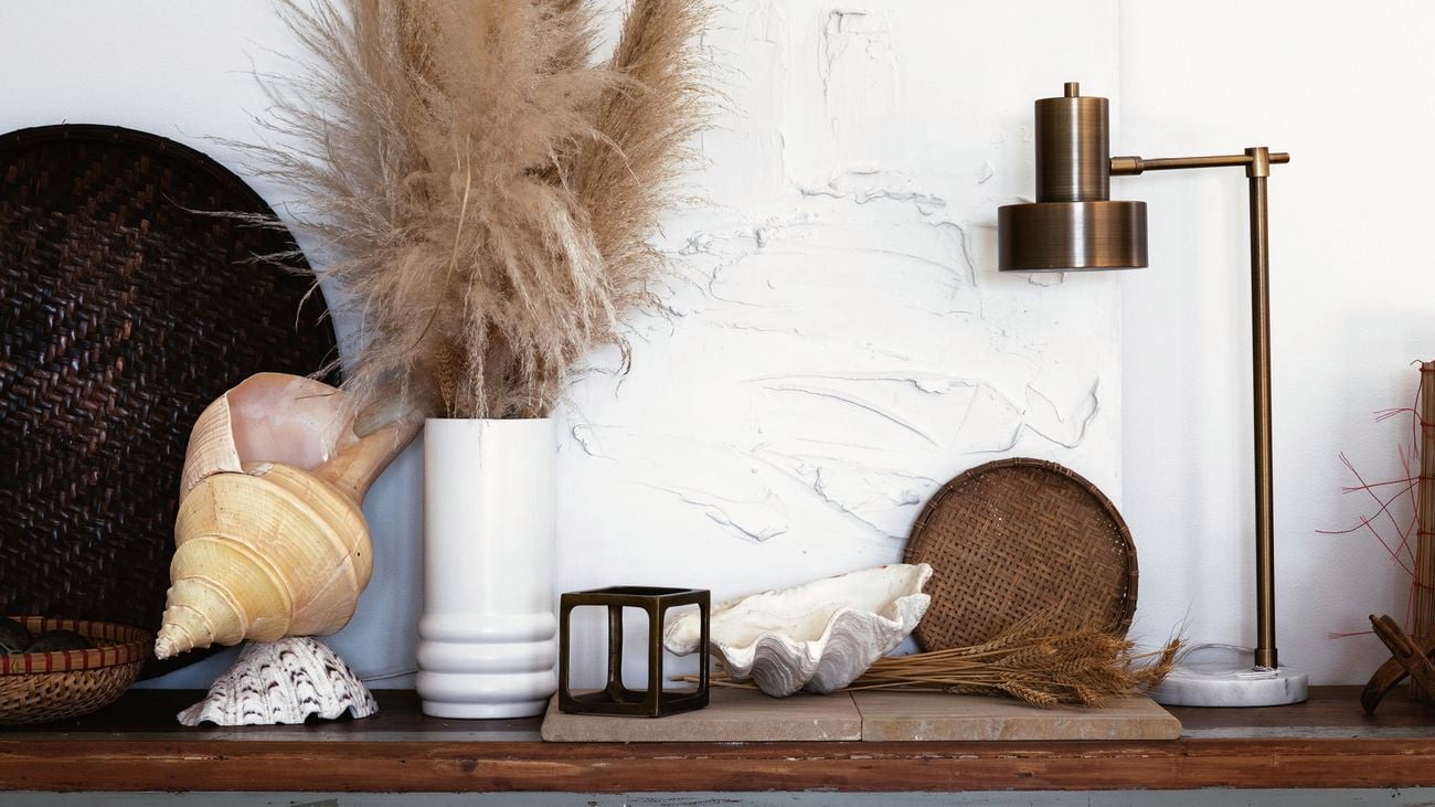Marble wall with various decor items in front.