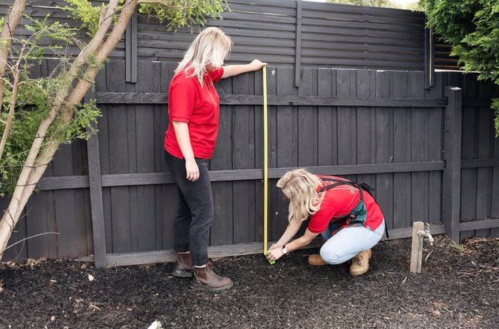 Person measuring fence.