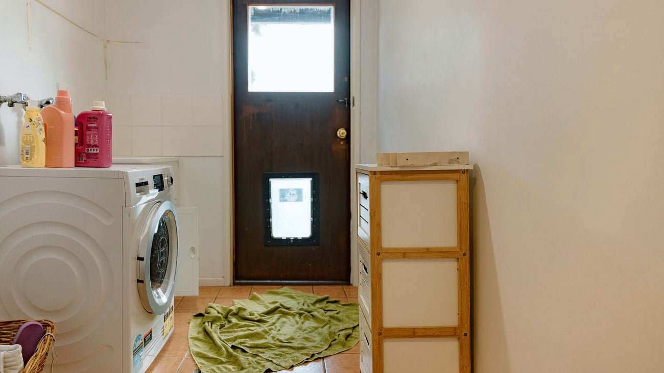  laundry with doggy door and terracotta floor tiles