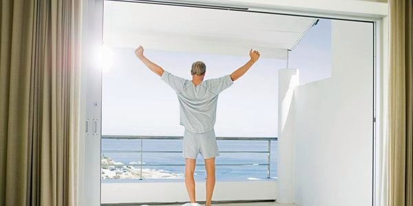 man standing in front of a window stretching