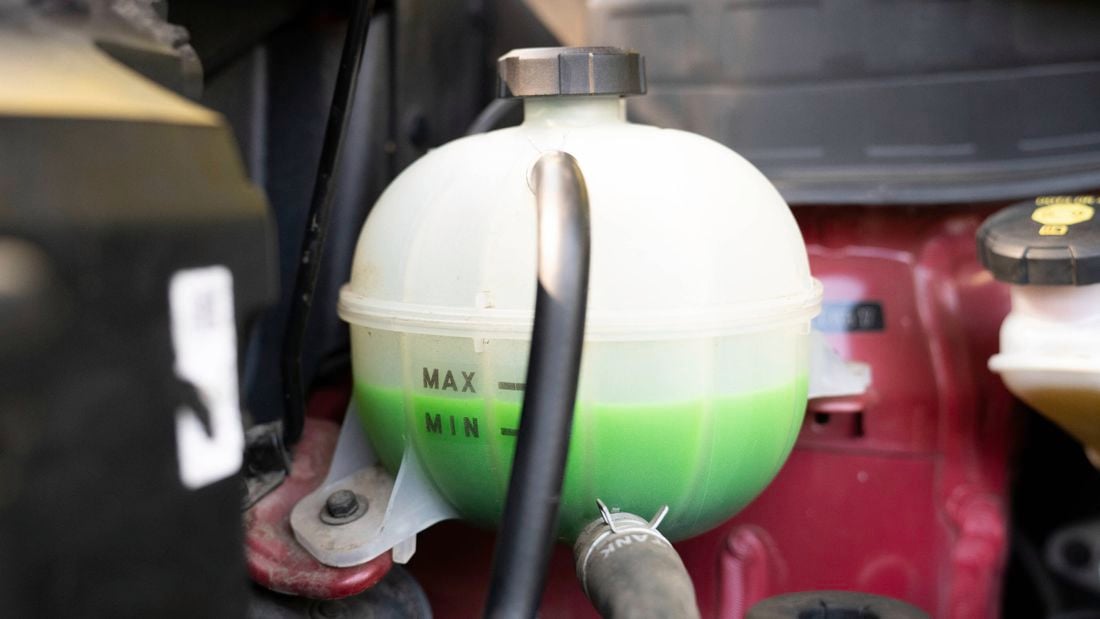Car coolant reservoir is filled with green coolant