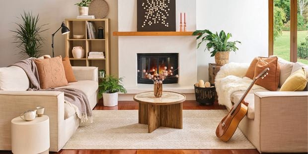 Styled living room with two couches, coffee table and fireplace.