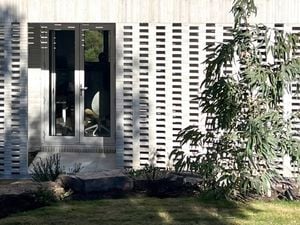 House with white brick exterior and glass panel door.