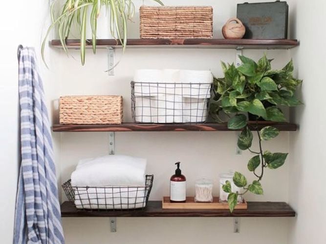A powder room with shelving in it above a toilet