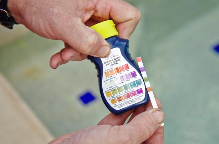 A pool test kit being used to measure the pH level, chlorine level, alkalinity and stabiliser