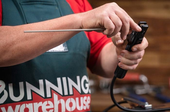 Bunnings team member preparing electrode for stick welding.