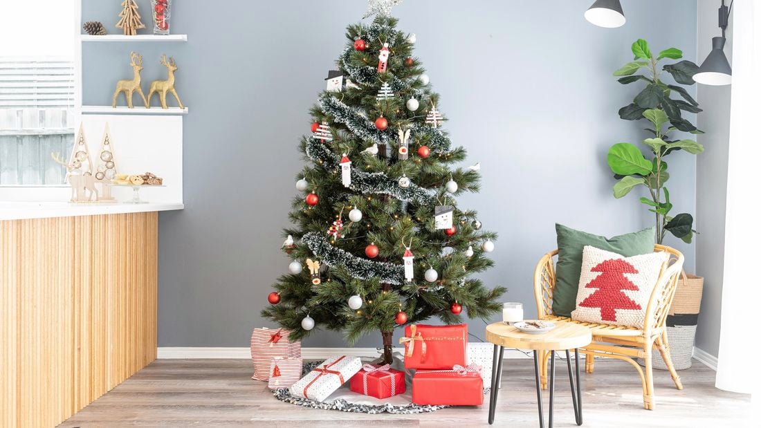 Traditional Christmas tree with handmade decorations set up in modern living room