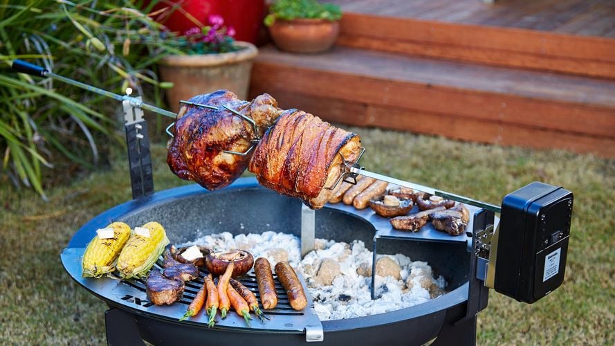 Meat and vegetables cooking on a Pit n Grill fire pit.