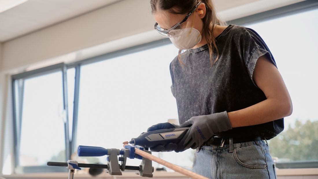 Person using Dremel sanding tool on timber