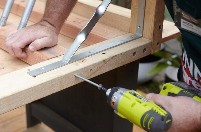 A person joining two pieces of pine at right angles using a bugle screw