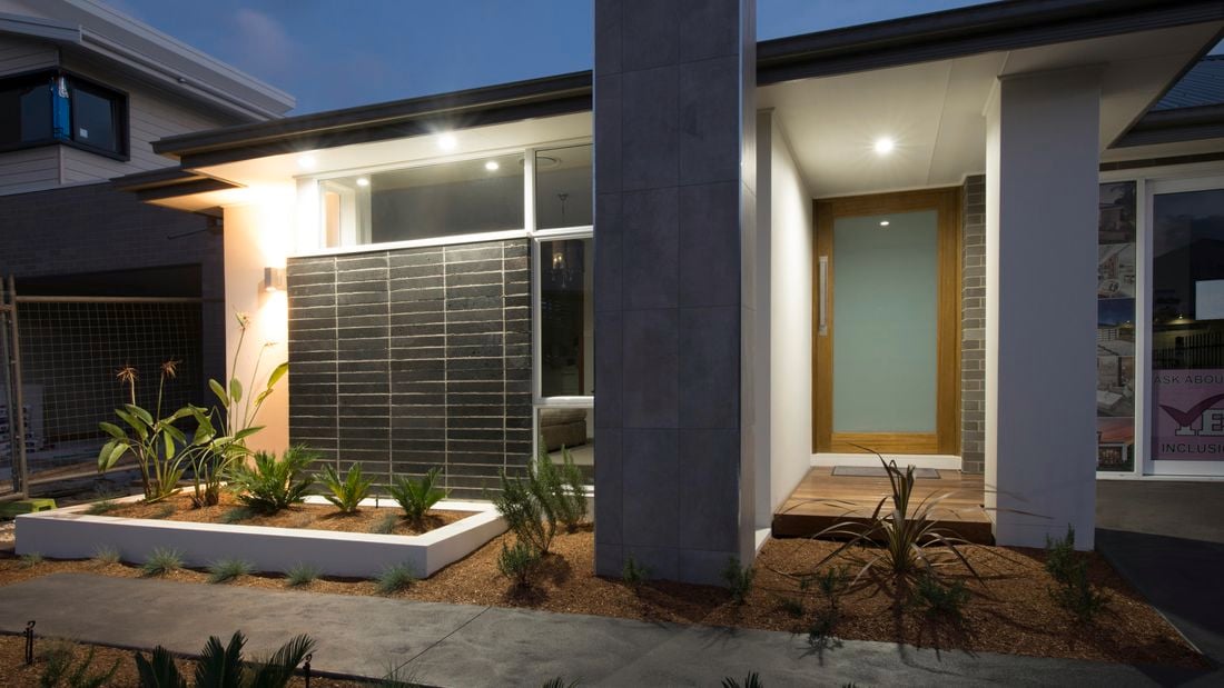 The exterior of a modern house with a frosted glass front door.