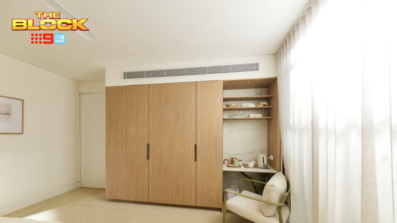 Contemporary bedroom featuring built-in timber wardrobes, open shelving, an armchair and floor-to-ceiling sheer curtains.