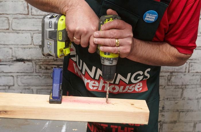 Person drilling into timber.