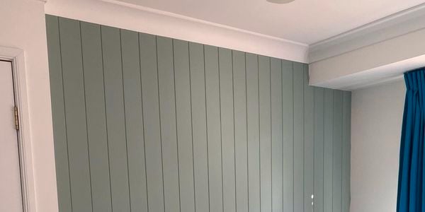 Blue painted internal timber panelled wall in a bedroom