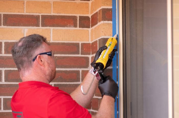 A Bunnings team member is applying the caulk.