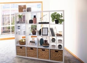 Cube unit with woven boxes, plants and other decorative items.