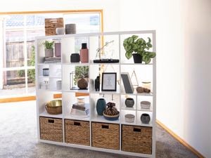 Cube unit with woven boxes, plants and other decorative items.