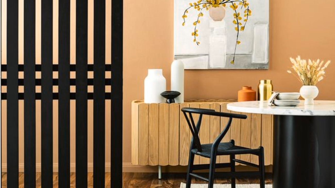 Dining table sitting on timber fall with black timber feature wall divider