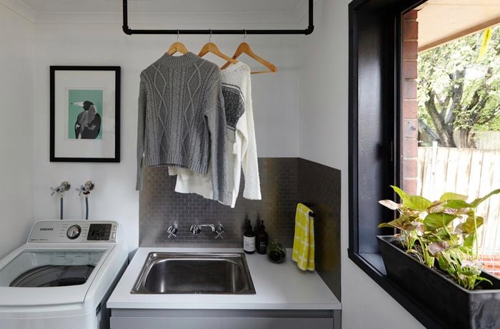 Clothes hanging on a pipe rack over the sink.