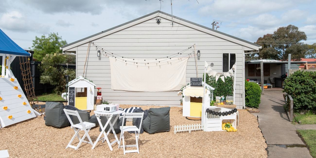 Completed kids backyard with outdoor cubbies, three piece outdoor setting, outdoor bean bags and play equipment.