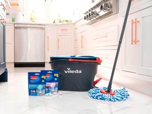 Vileda mop and bucket on a kitchen floor beside two PACS packets