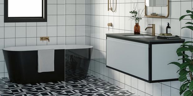 monochromatic bathroom with geometric floor tiles, freestanding bath and gold fixtures