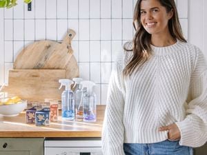 Woman standing in kitchen next to the Eco Turtle cleaning products on the bench