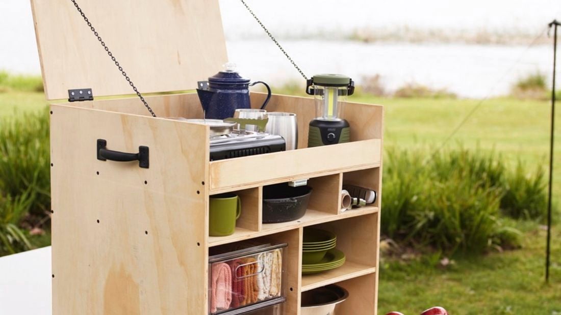 Fully assembled and kitted out camping kitchen box sitting on a tressle table ready to be used