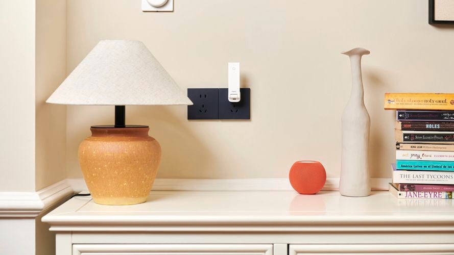 Aqara Hub M100 plugged into a wall socket in a living room