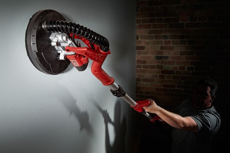 A construction worker using a drywall sander