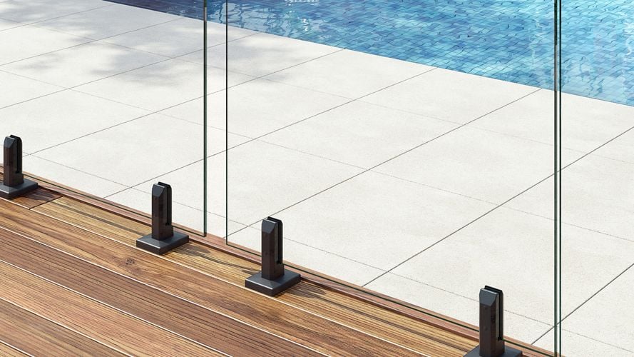 Brackets for a clear pool fence secured to a deck