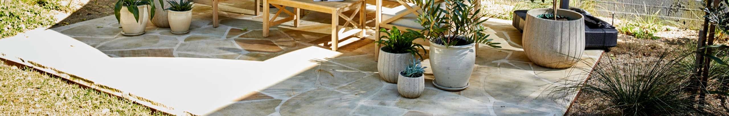 Outdoor area with an umbrella over an outdoor setting that is decorated with pots