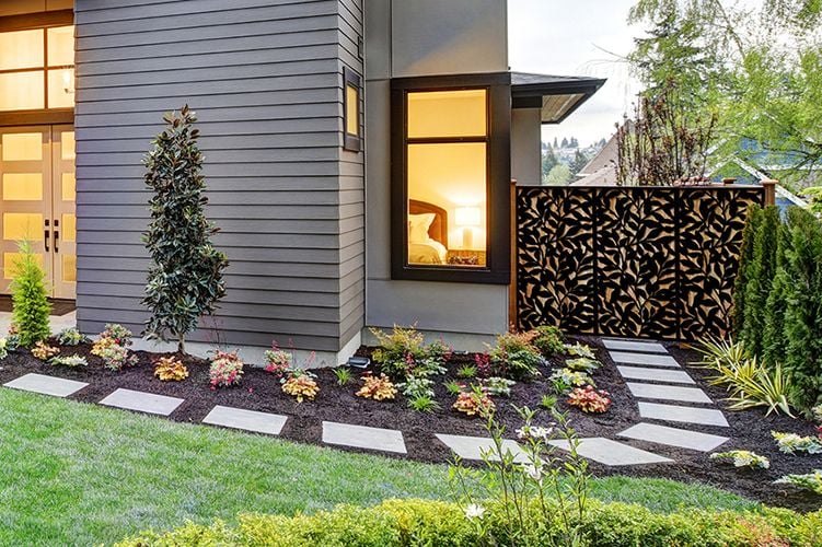 Garden bed with stepping stones, flowers, bushes and decorative screens
