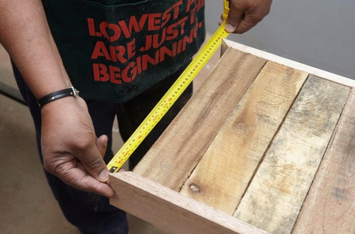 Person measuring width of tabletop