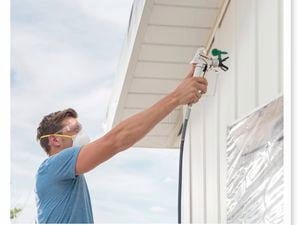 A Bunnings team member holding a paint sprayer