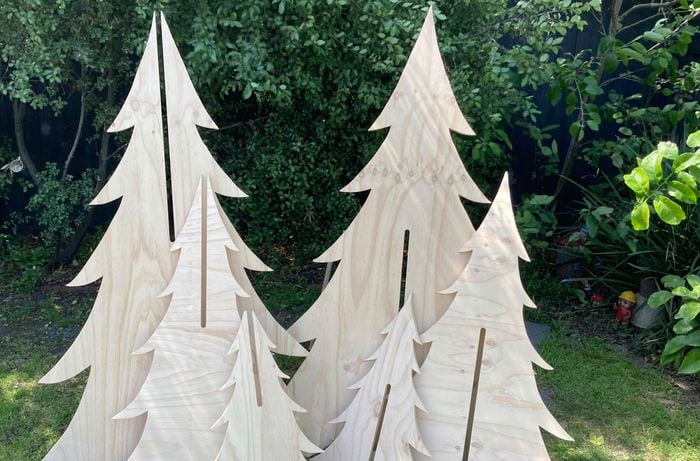 Un-assembled plywood Christmas trees stacked together.