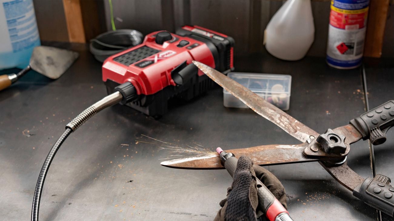 Person using a rotary tool kit on shears.