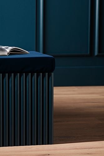 A seat built into a wall with wooden dowel panelling