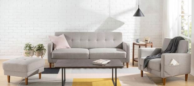 Lounge room setting with grey couch, armchair and ottoman