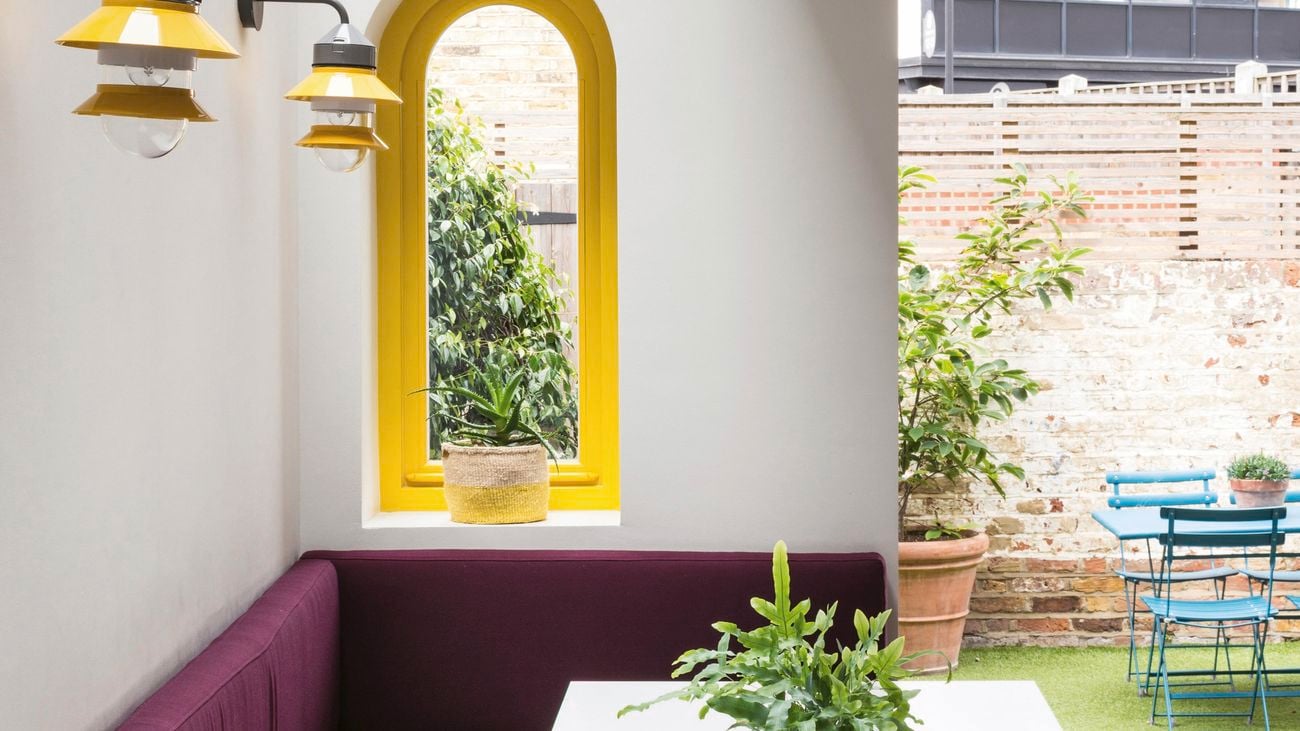 Indoor/outdoor area with yellow pendant lights and a courtyard with exposed brick.