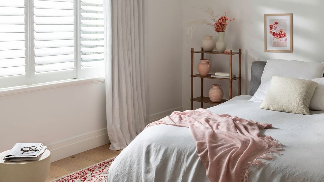 A cosy bedroom in a warm healthy home with a throw and rug