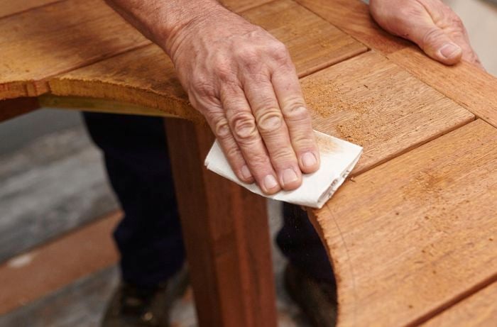 Person sanding around a circle cut out they have made in a table.