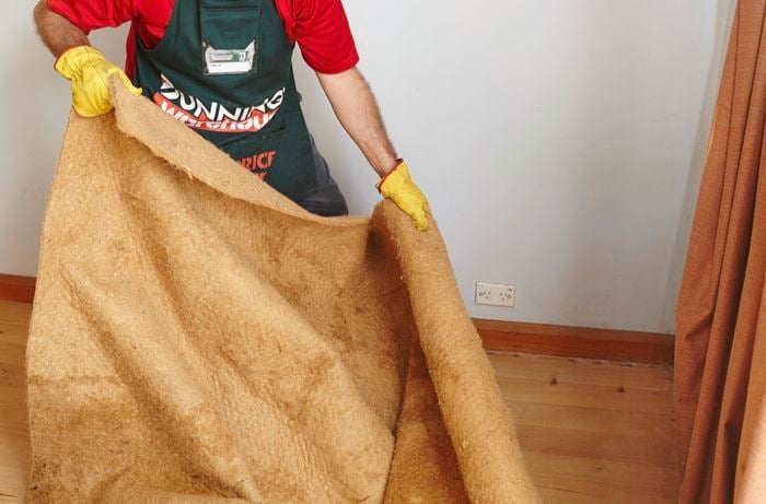 A person removing underlay from a floor