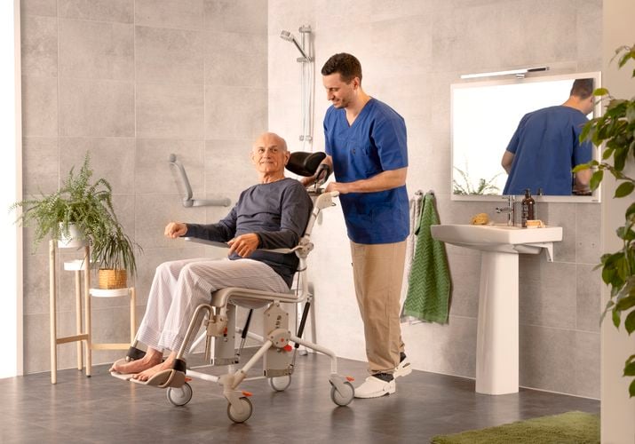 Man in wheelchair, he has a carer with him assisting in the bathroom
