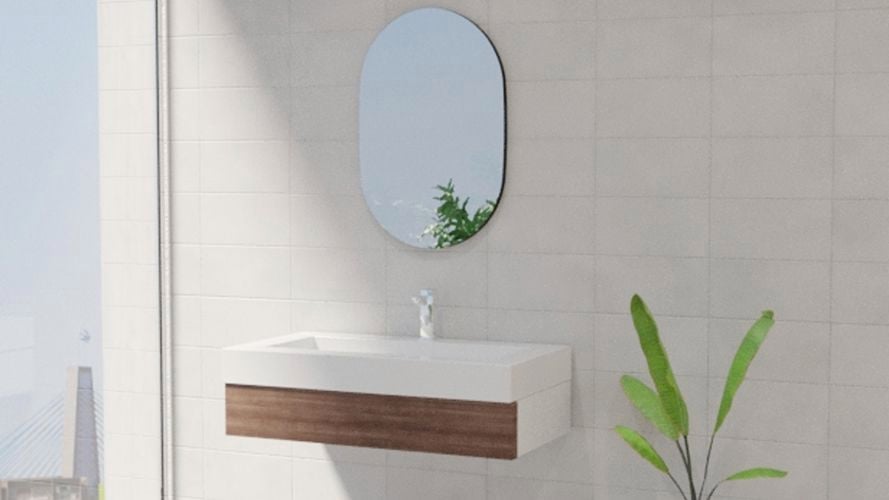 Bathroom with oval mirror along with wash basin, storage shelf plant and white wall tiles.