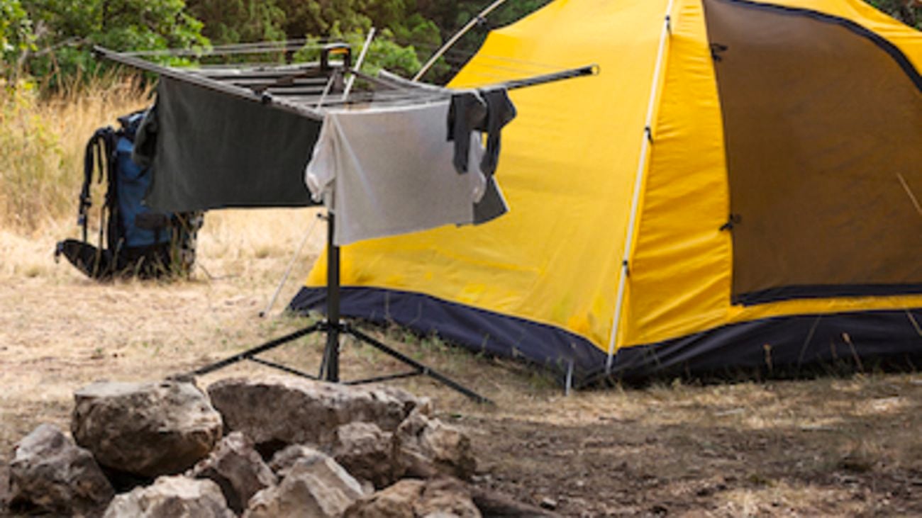 A portable clothesline outside of a yellow tent