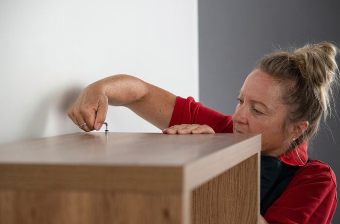 A Bunnings Team Member using an ellen key to screw in a screw to a shelving unit