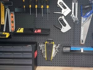 Tools and equipment hanging on a pegboard.